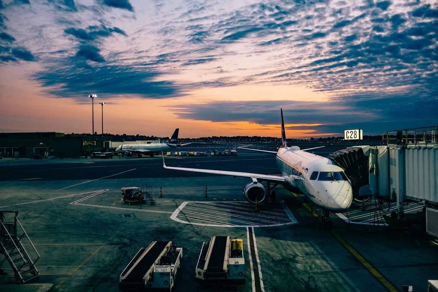 Aeronave no portão do aeroporto, conectada à ponte de embarque ao anoitecer